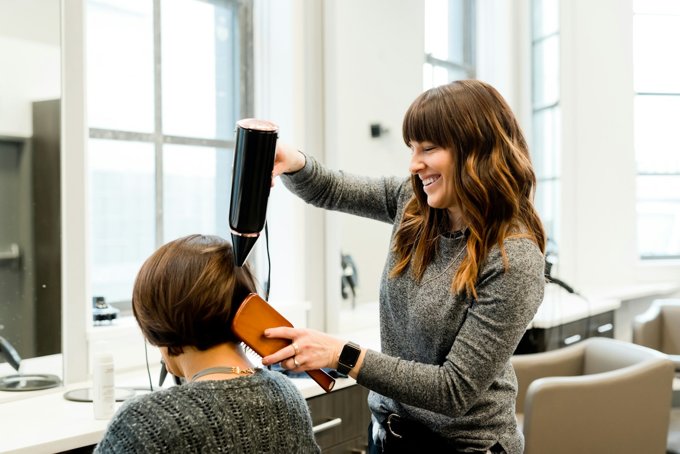 A hairdresser welcoming a customer in a bright salon